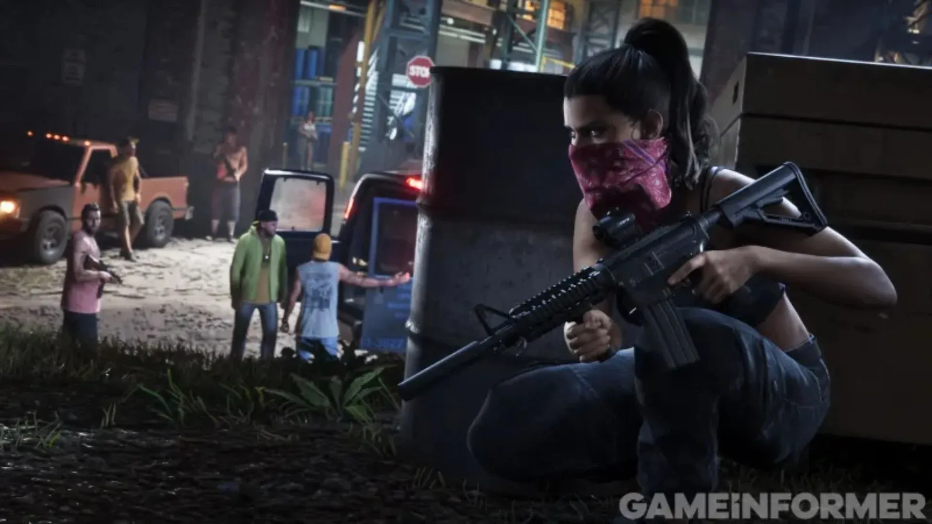 Lucia, bandana rose sur le visage et fusil d’assaut en main, accroupie derrière un baril, surveille de nuit un groupe d’hommes près d’un pick-up.