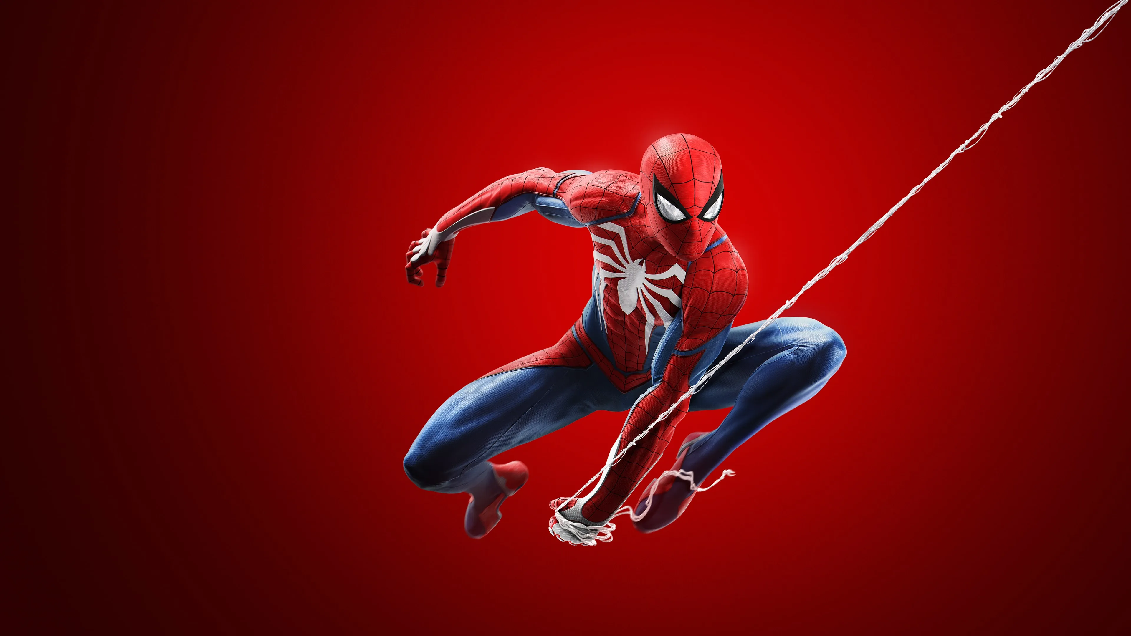 Spider-Man en costume rouge et bleu se balance à une toile sur un fond rouge dans le visuel officiel de Marvel’s Spider-Man Remastered.