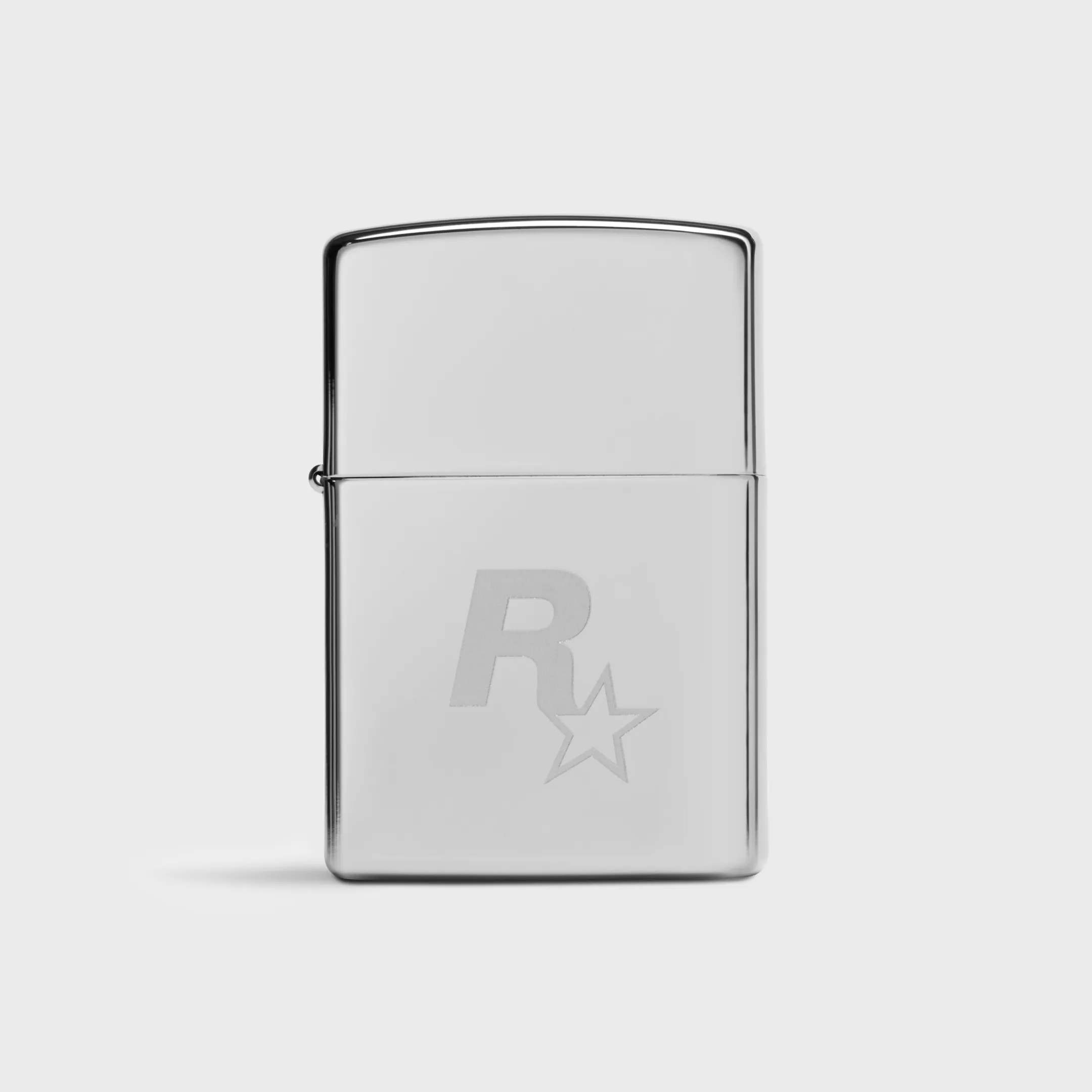 Un briquet Zippo chromé fermé présente le logo Rockstar Games gravé sur sa face avant.