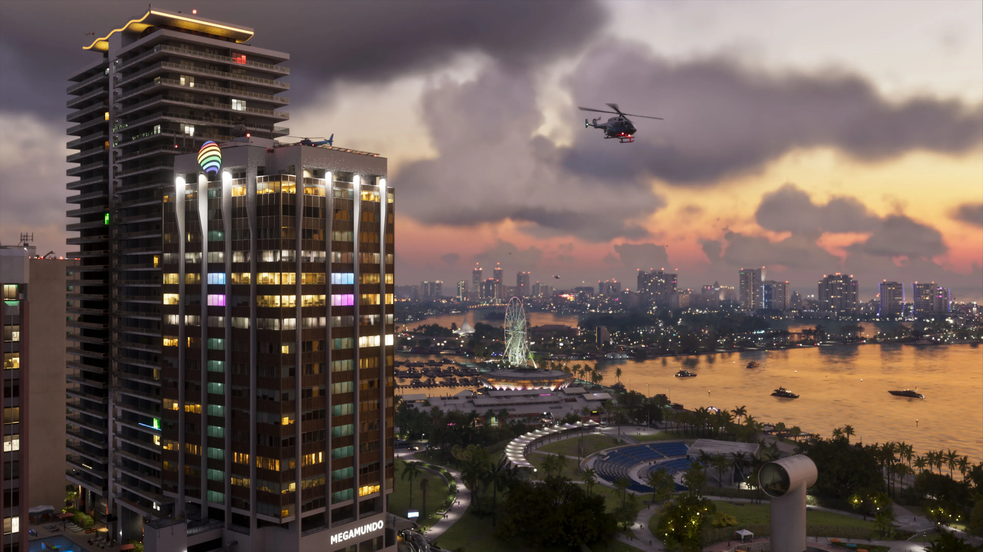 Un hélicoptère survole les immeubles de Vice City au coucher du soleil, au-dessus d’une baie éclairée.
